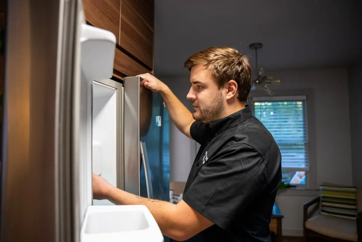 Mr. Fixer technician repairing a refrigerator
